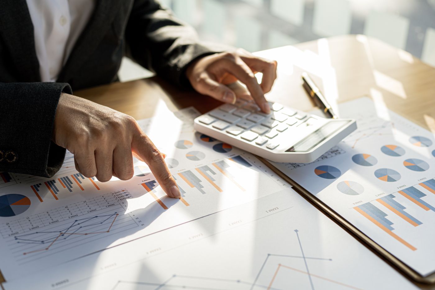 Businessman Using A Calculator To Calculate Numbers On A Company's Financial Documents, He Is Analyzing Historical Financial Data To Plan How To Grow The Company. Financial Concept. - Auster Inteligência Contábil