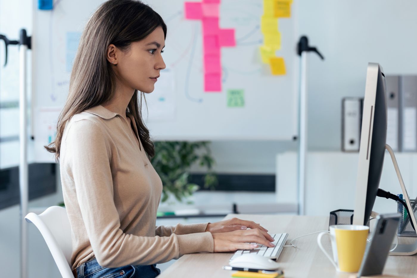 Beautiful Young Business Woman Working With Computer While Sitti - Auster Inteligência Contábil