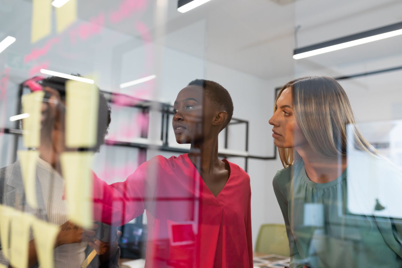 Diverse Group Of Business Colleagues Brainstorming Using Glass Wall In Meeting Room. Business In A Modern Office. - Auster Inteligência Contábil