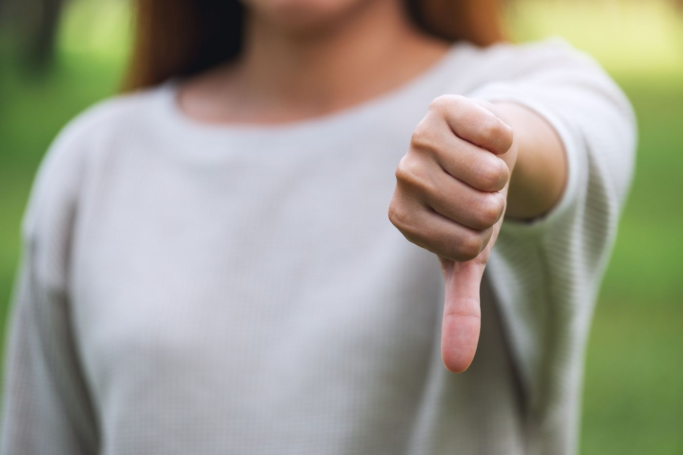 Closeup Image Of A Woman Making Thumbs Down Hands Sign - Auster Inteligência Contábil