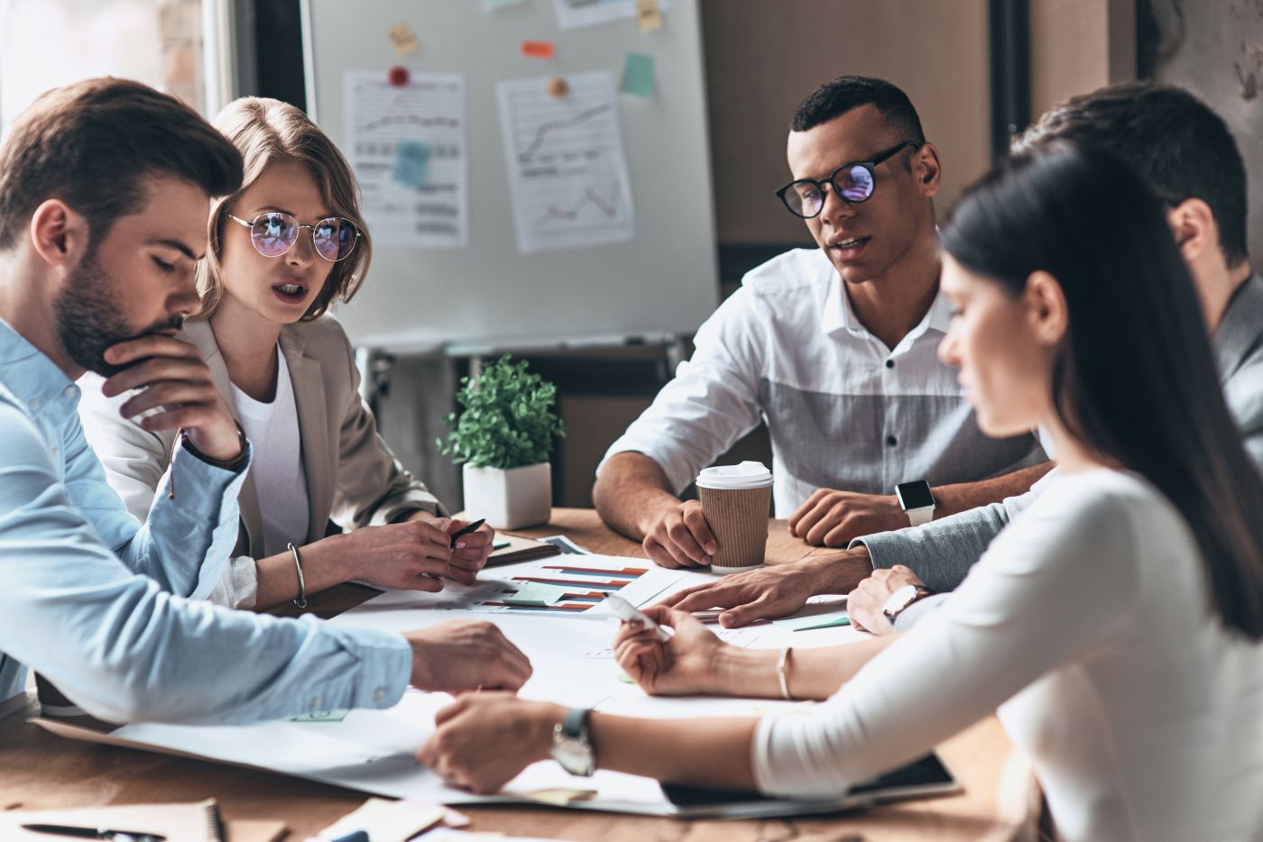 Brainstorming. Young Modern People In Smart Casual Wear Working Using Blueprint While Sitting In The Creative Office - Auster Inteligência Contábil