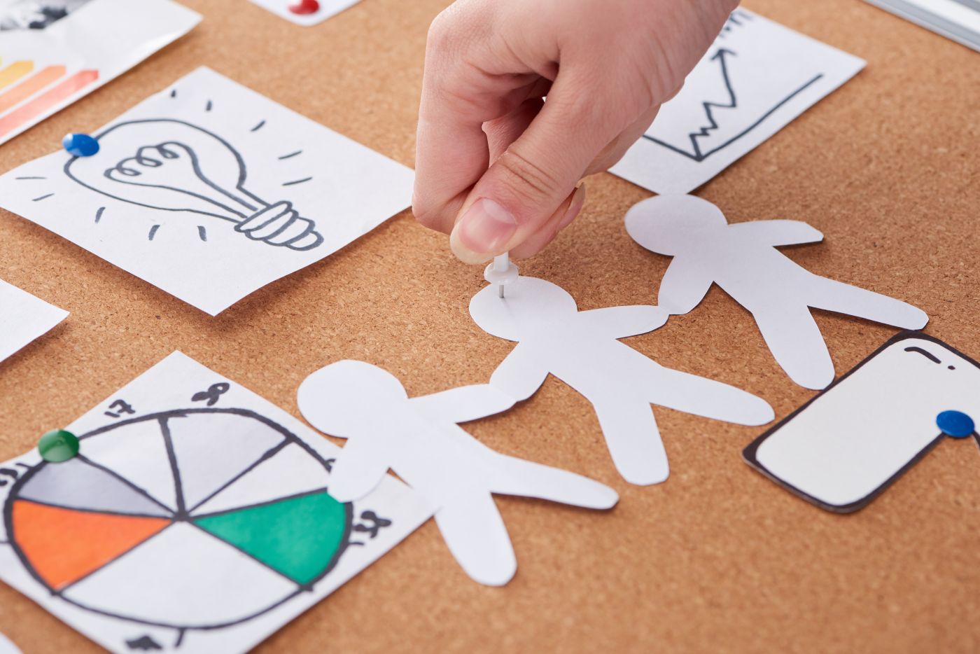 Cropped View Of Woman Pinning Paper Craft Decoration On Cork Board - Auster Inteligência Contábil