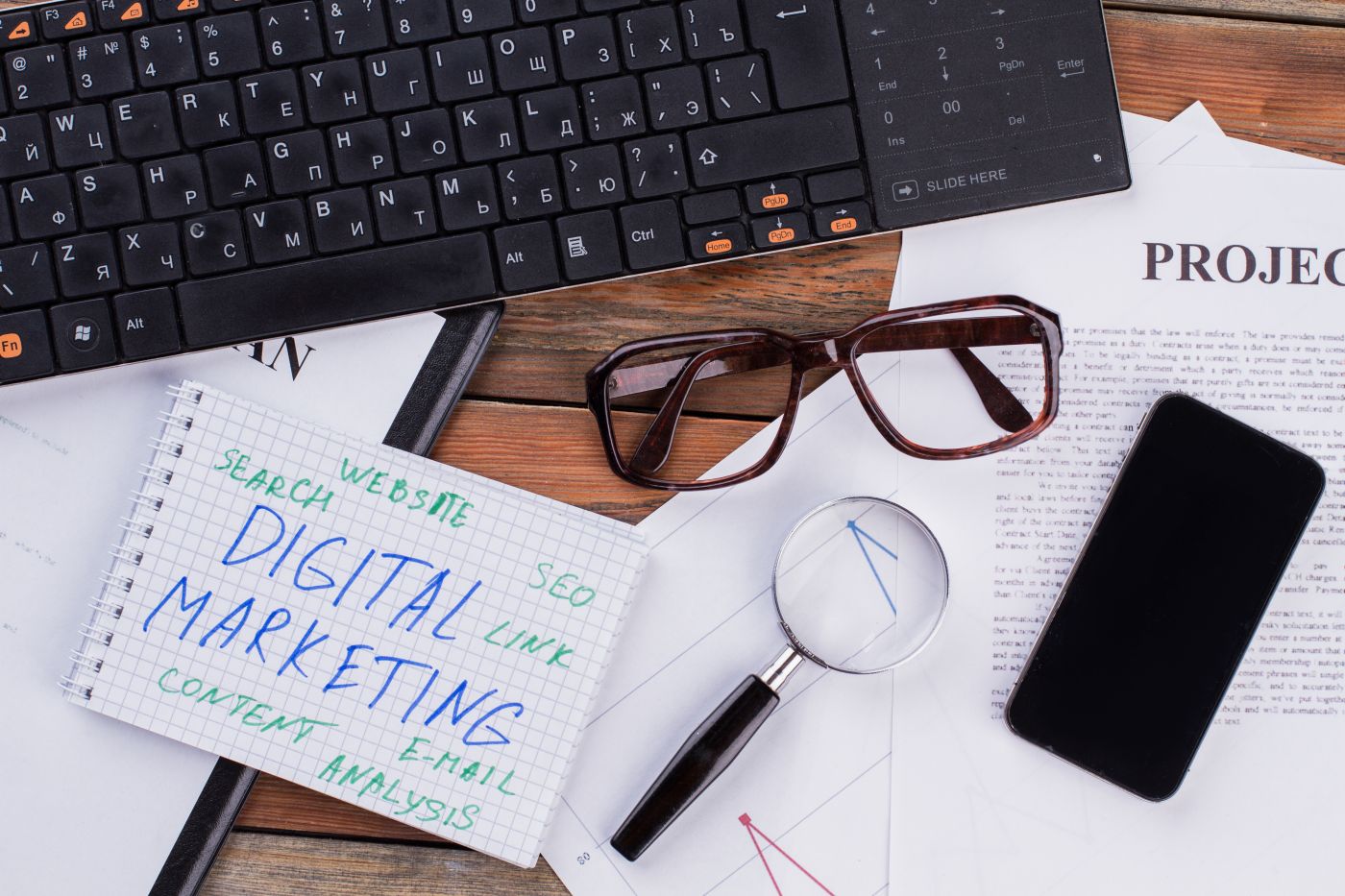 Digital Marketing On Notepad And Various Business Papers On Brown Background. - Auster Inteligência Contábil