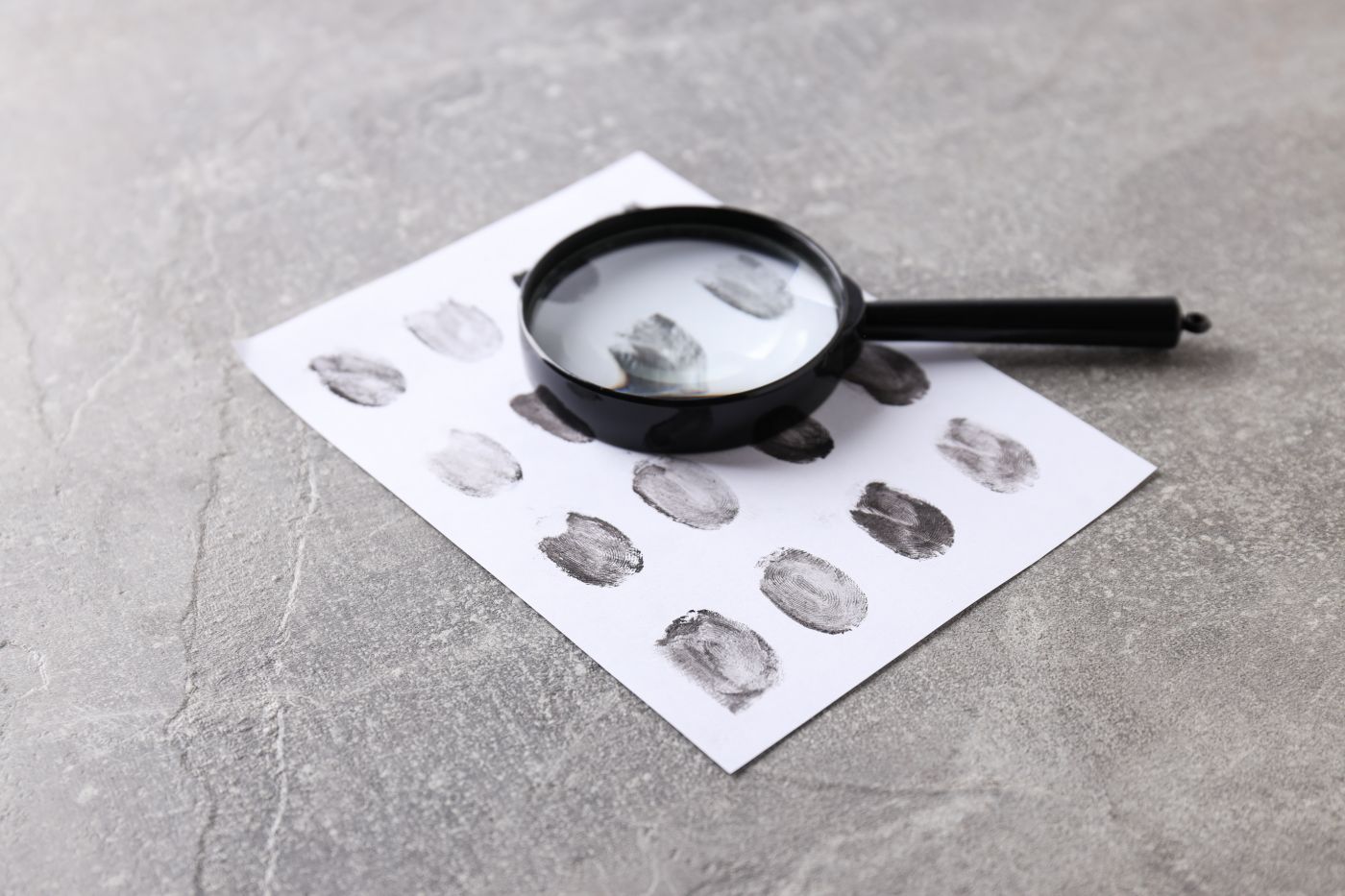 Magnifying Glass With Fingerprints On A Light Background - Auster Inteligência Contábil