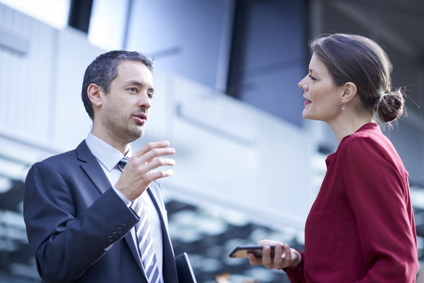 Businessman And Woman Talking In Office Atrium - Auster Inteligência Contábil